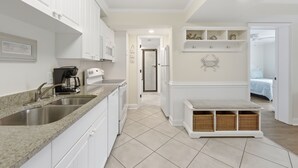 A modern kitchen with white cabinetry, a granite countertop, and a built-in sink.