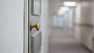 Un pasillo con una puerta y un picaporte de latón.