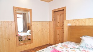 Una habitación con paneles de madera, una cama, un espejo y una puerta.