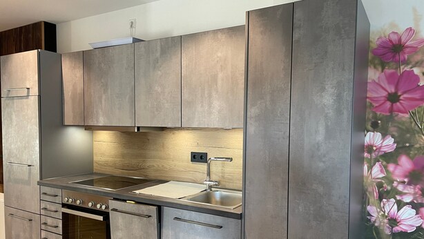 Una cocina moderna con electrodomésticos de acero inoxidable, armarios de madera y una salpicadera.