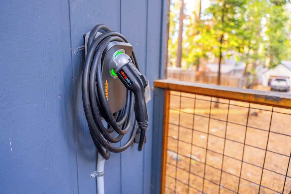 A charging station with a cable coiled on a wall.