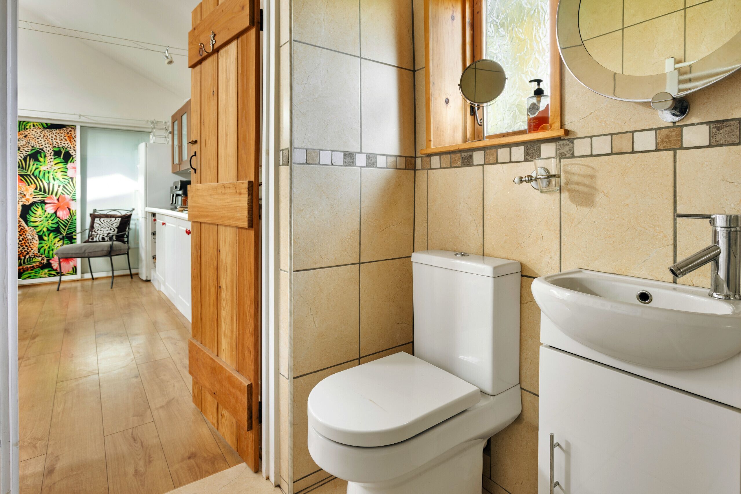 Een badkamer met toilet, wastafel en een houten kastje.