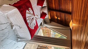 A bed with a red blanket and pillows, a wooden headboard, and a view of the outside through a window. - VASTO HORIZONTE TURISMO (Barreirinhas)