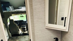 Ein kleines Badezimmer mit Waschbecken, Toilette und einem Fenster.