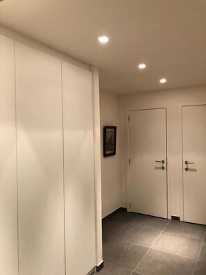 Ein Flur mit einem Schrank, einer Tür und einem gerahmten Bild an der Wand.