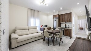 Un apartamento moderno con sala de estar, comedor, cocina y televisor.