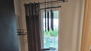 Ein stilvoller Essbereich mit einem runden Tisch, schwarzen Stühlen, einem schwarzen Schrank und Blick durch ein Fenster.