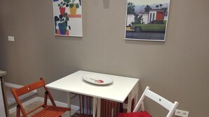 A small room with a white table and two chairs, one with a red cushion. - Spacious 4-bedroom condo in tranquil Alcalá de Henares -One-Bedroom Apartment (Alcalá de Henares)
