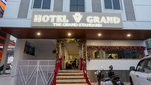 A hotel entrance with a grand sign, a staircase, and a red carpet. - Hotel V Grand (Hyderabad)