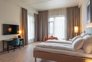 A hotel room with a bed, a desk, a chair, a television, and curtains. - Thon Hotel Drammen (Drammen)