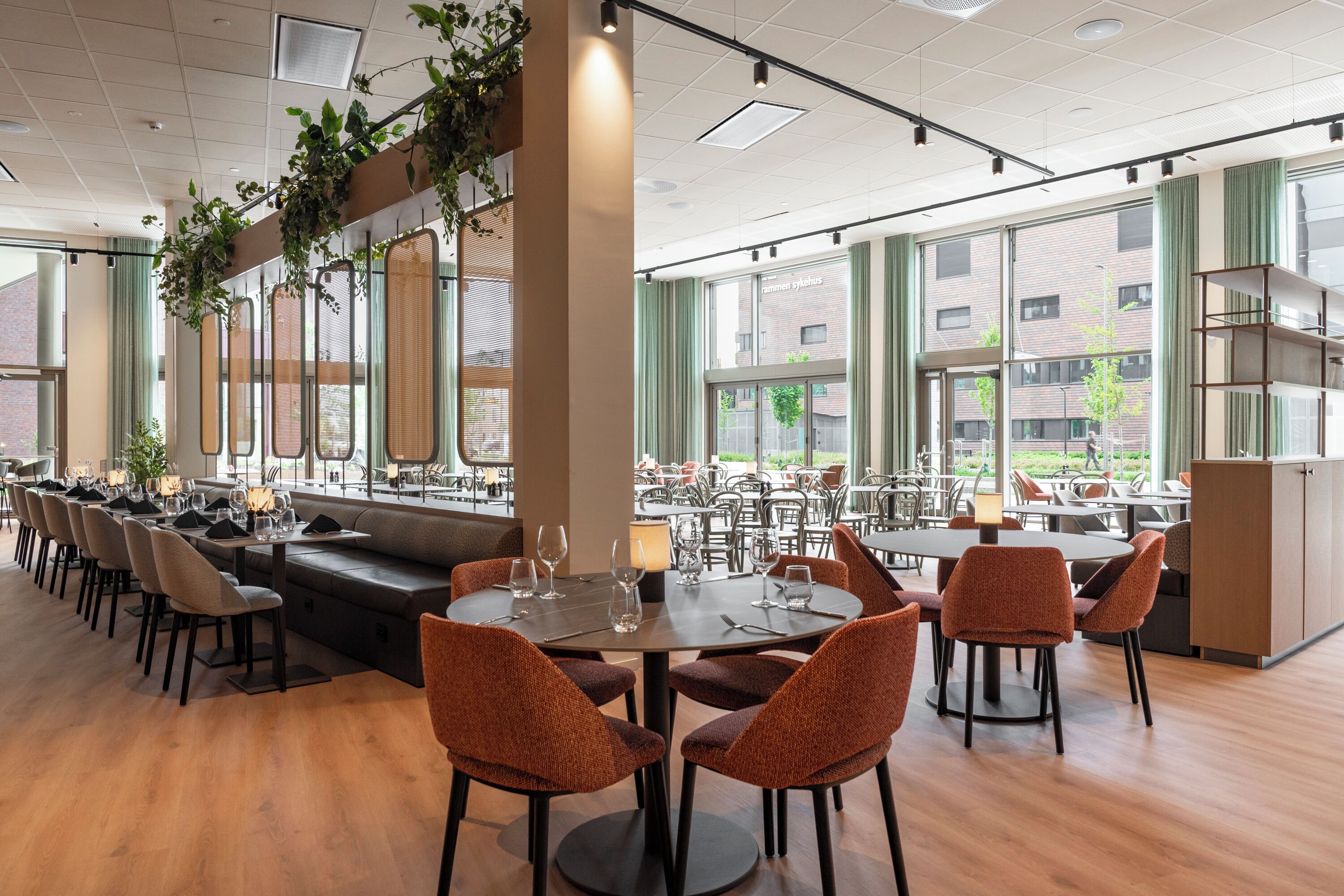 A spacious restaurant with high ceilings, large windows, and a variety of seating options including tables and booths.
