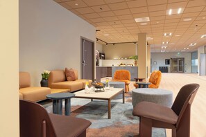 A modern lobby with seating, a coffee table, and a kitchen area in the background. - Thon Hotel Drammen (Drammen)