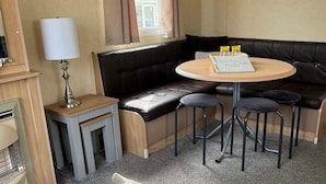 A corner seating area with a round table, a small side table, and a lamp.