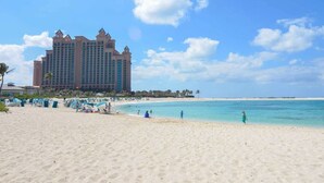 Una playa con un gran hotel al fondo.