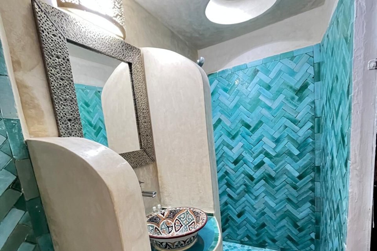 A bathroom with a toilet, a sink, and a shower area.
