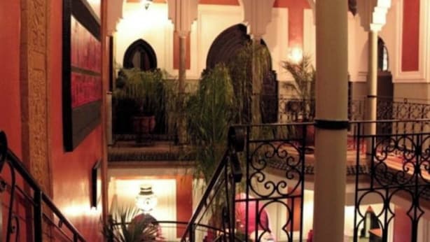 A hotel lobby with a staircase, arched ceilings, and a fountain. - Riad Kantarell (Marrakech)