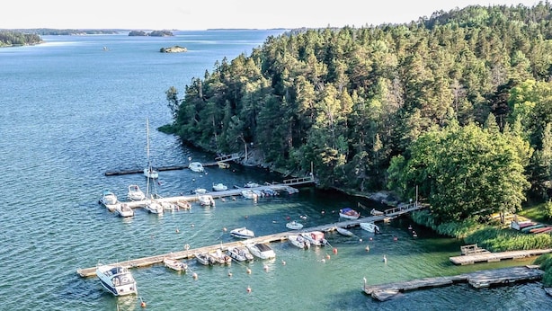A marina with boats docked, surrounded by dense forest and calm water. - 4 Star Holiday Home in Sorunda (Sorunda)