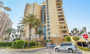 A multi-story hotel with balconies, palm trees, and a no entry sign. - Marina Residence - Mint Stay (Dubai)