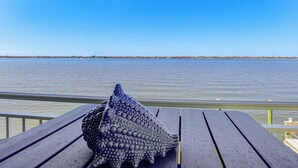 A wooden bench with a large stingray on it, overlooking a calm body of water with a distant shoreline. - Waterfront Resort Home! Extended Jensen Beach Stay (Jensen Beach)