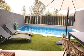 A backyard with a swimming pool, artificial grass, lounge chairs, and a table. - Casa Aire de Mar (Caleta de Vélez)