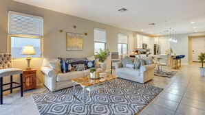 Ein geräumiges Wohnzimmer mit zwei Sofas, einem Couchtisch und einem Essbereich mit Bar.