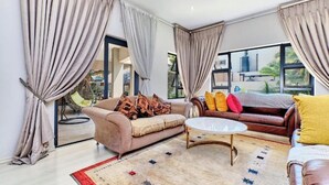 Una sala de estar con dos sofás, una mesa de centro y vista al exterior.