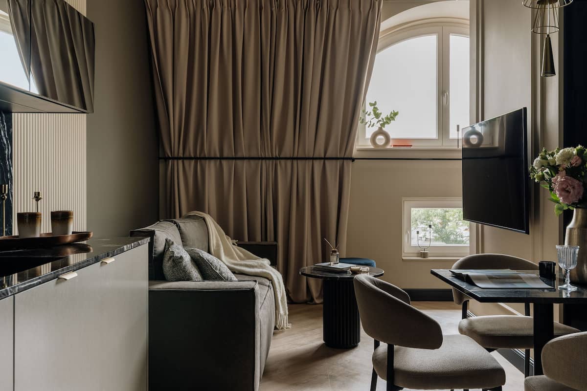 Una sala de estar moderna con un sofá, una mesa de comedor y un televisor.