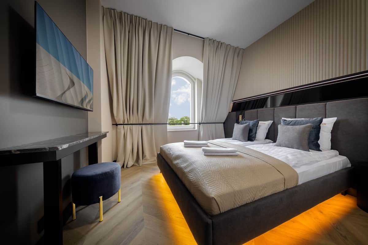 Un dormitorio moderno con una cama, un escritorio y una ventana con cortinas.