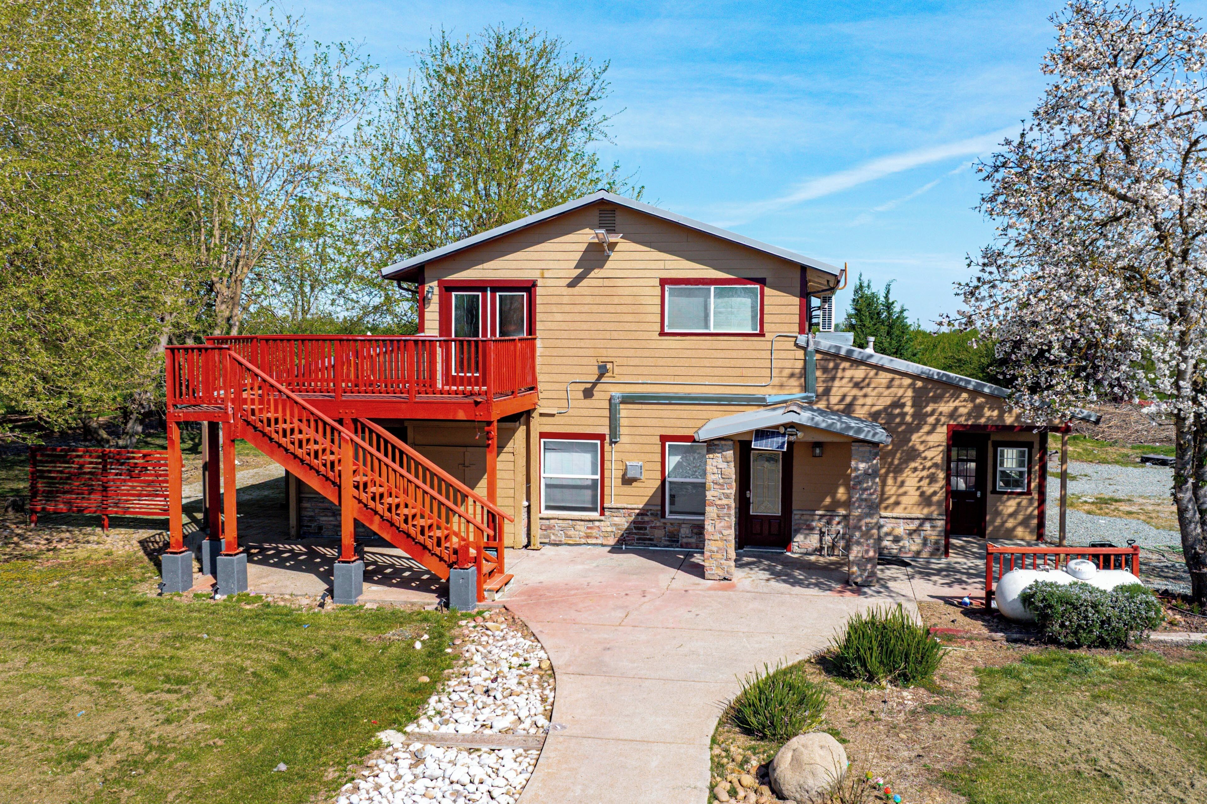A two-story house with a red staircase, a front porch, and a small attached garage.
