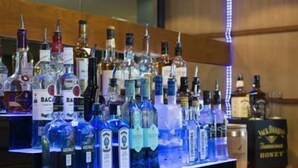 Uma área de bar com diversas garrafas de bebidas alcoólicas.