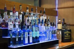 Uma área de bar com diversas garrafas de bebidas alcoólicas.