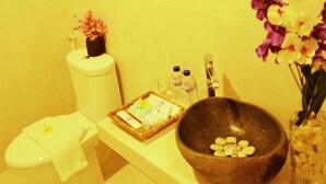 Une salle de bain équipée de toilettes, d’un lavabo et d’un grand bac en pierre.