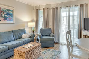 Ein Wohnzimmer mit Sofa, Sesseln, Couchtisch und Fernseher.
