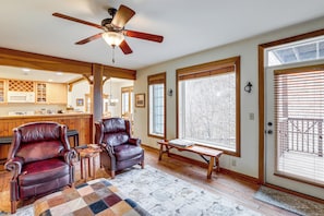 A spacious living area with a ceiling fan, large windows, a fireplace, and a cozy seating arrangement. - Forest-view Balcony & Trail Access! Burnsville Gem (Burnsville)
