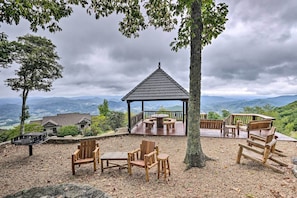 A gazebo with a wooden deck, surrounded by wooden chairs and tables, overlooking a mountainous landscape. - Forest-view Balcony & Trail Access! Burnsville Gem (Burnsville)