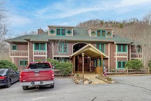 A two-story building with a covered porch, a garage, and a red pickup truck parked in front. - Forest-view Balcony & Trail Access! Burnsville Gem (Burnsville)