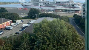 Een uitzicht op een cruiseschip dat in een haven ligt, met een heldere lucht.