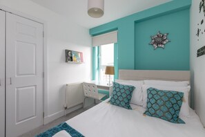 Une chambre à coucher avec un lit, un radiateur, un bureau et une fenêtre.