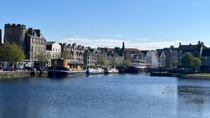 Stadsgezicht aan het water met historische gebouwen, een rivier en boten.