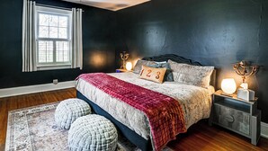 A bedroom with a bed, bedside lamps, a nightstand, a window with curtains, and a rug. - Historic Group Retreat w/ Pool in Paducah (Paducah)