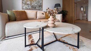 Una sala de estar moderna con un sofá, una mesa redonda de centro y un jarrón decorativo.
