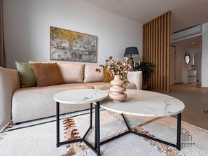 A modern living room with a sofa, a round coffee table, and a decorative vase. - Arletta - Panoramic View (Sarandë)