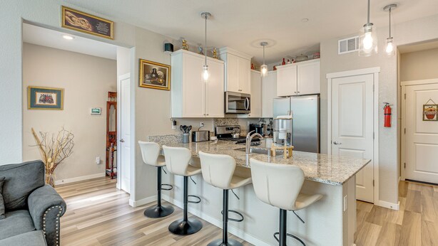 A modern kitchen with a central island, bar stools, and stainless steel appliances. - Explore, Shop & Relax! Getaway in West Sacramento (West Sacramento)