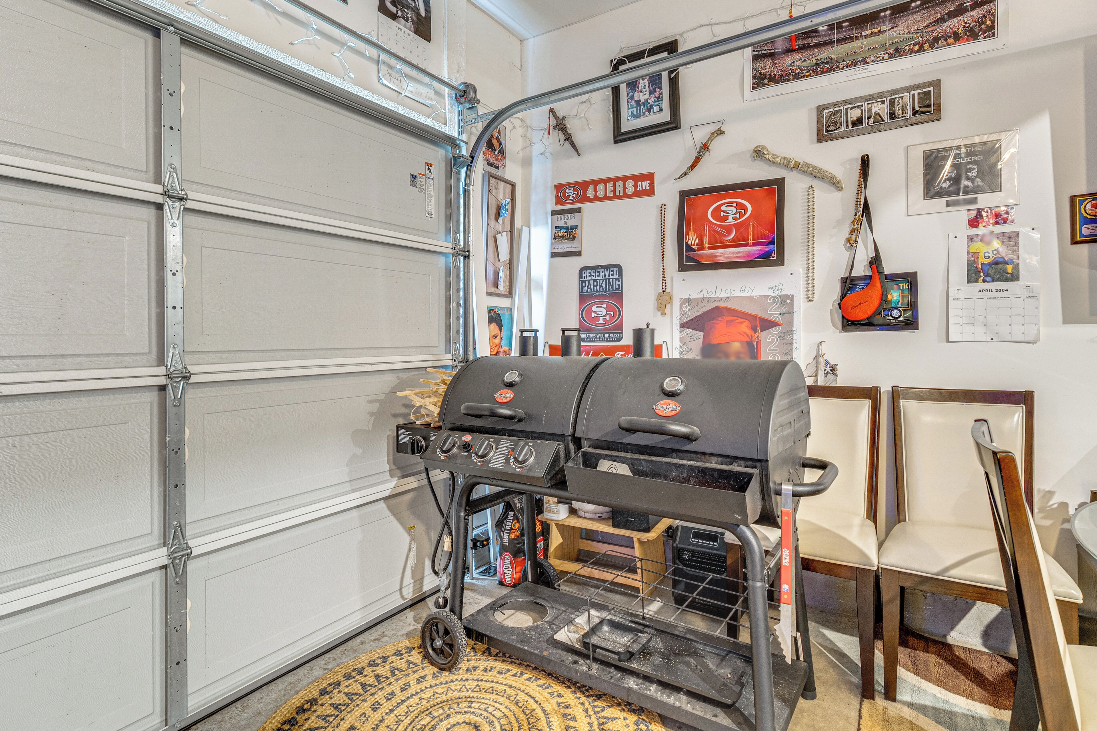 A garage with a barbecue grill, a calendar, and various wall decorations.