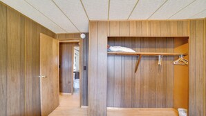 A bedroom with wooden walls, a bed, a wardrobe, and a walk-in closet. - Outdoor Adventure Base in the Heart of Miller (Miller)