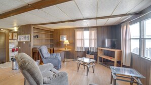 A living room with a sofa, armchair, TV, and wooden shelves. - Outdoor Adventure Base in the Heart of Miller (Miller)