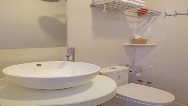 A bathroom with a white sink, toilet, and shower. - Daystar Hotel (Da Nang Municipality)