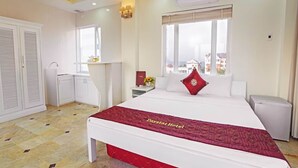 A hotel room with a bed, a window, a bedside table, a nightstand, a wardrobe, and an air conditioning unit. - Daystar Hotel (Da Nang Municipality)