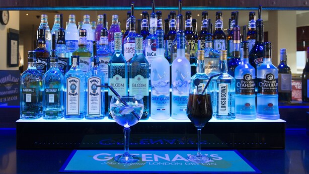 A bar with a variety of liquor bottles and a glass with a drink. - Holiday Inn Express Newcastle City Centre (Newcastle-upon-Tyne)
