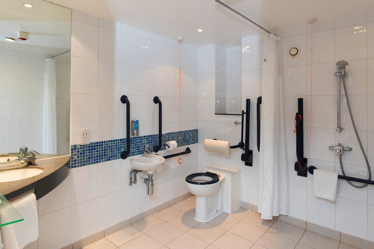 A modern bathroom with a sink, toilet, and shower.
